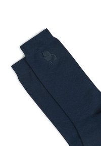 Calzini di cotone blu navy con texture a costine e ricamo del logo discreto sulla caviglia. Lunghezza a metà polpaccio, finitura liscia.