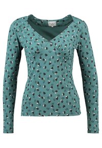 Vihreä pitkähihainen istuva paita, jossa on V-pääntie, rypytetty yksityiskohta rintojen alla ja pieni musta-, valkoinen- ja sinikukkakuvio.