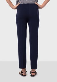 Mörkblå byxor med rak bendesign, tillverkade av ett slätt material, med en elastisk midja och minimala sömmar.