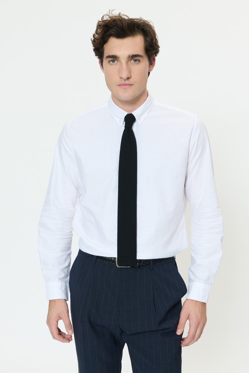 White button-up shirt, black knitted tie, and navy pinstripe trousers. Classic design with a smooth texture and tailored fit.