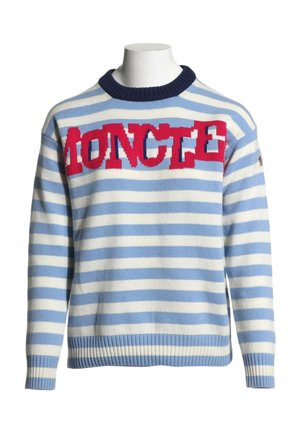Jersey de rayas azules y blancas con cuello azul oscuro y texto rojo llamativo en el pecho, exhibido en un torso de maniquí blanco.