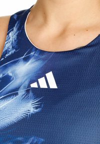 Blauw sportieve tanktop met een gestructureerd patroon en een wit logo met drie oplopende strepen bij de halslijn.
