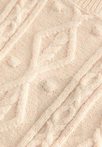 Gestrickter Pullover in hellbeige, mit strukturierten Mustern und erhabenen Stichen. Weiches, warmes Material mit filigranen Details.