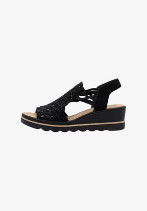 Schwarze Keil-Sandalen mit einem dekorativen Spitzenmuster, offenem Zehenbereich, Wildleder-Oberfläche und einer gepolsterten Innensohle mit gewellter Außensohle.
