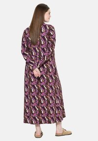 Vestido largo y estampado con motivos de hojas en púrpura, rosa y marrón, de mangas largas y corte relajado, confeccionado en un tejido ligero.