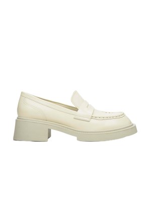Cream-colored loafers with a low block heel, featuring a smooth leather finish, decorative stitching, and a rounded toe design.