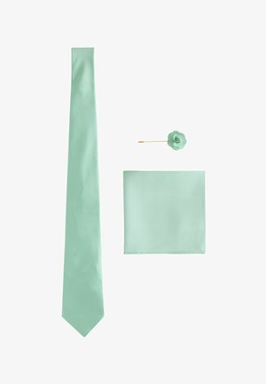 Hellgrüne Herren-Krawatte, passendes Einstecktuch und Blumen-Anstecknadel mit goldenem Stiel auf weißem Hintergrund arrangiert.