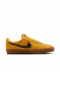 Sneakers Nike in suede giallo brillante con accenti neri, suola in gomma piatta e punta arrotondata. Presentano dettagli cuciti e logo sulla linguetta.