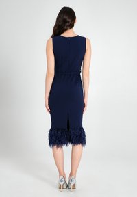 Marineblaues Kleid mit einer taillierten Silhouette, einem Schlitz im Rücken und einer Federbesatzkante. Glattes Material und einfacher Rückenverschluss.