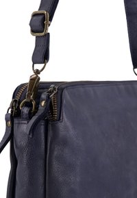 Marineblaues Lederhandbag mit strukturierter Oberfläche, ausgestattet mit einem Metallreißverschluss und Hardware-Akzenten. Beinhaltet einen verstellbaren Trageriemen für Vielseitigkeit.