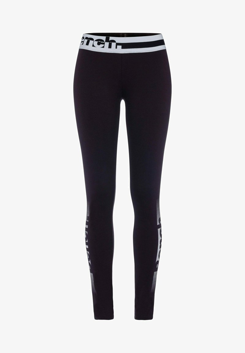 Schwarze Leggings mit einem breiten weißen Bund, der Logo-Text aufweist. Die Seitenpaneele haben ein geometrisches Mesh-Muster. Die Passform ist schlank und enganliegend.