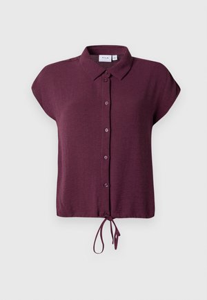 Blouse à manches courtes de couleur bourgogne profond avec un col, une fermeture à boutons sur le devant et un détail noué à l'ourlet. Tissu doux avec une texture subtile.