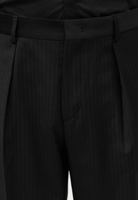 Μαύρο παντελόνι με ριγέ σχέδιο, ραμμένο στα μέτρα σας, με θηλιές για ζώνη και κρυφό μπροστινό φερμουάρ.