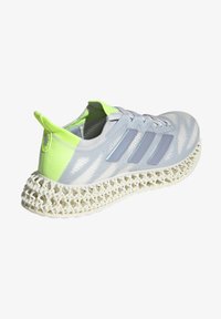 Sneaker atletica grigio chiaro con una tomaia testurizzata, dettagli in verde neon e un distintivo design della suola a reticolo bianco. Tre strisce sul lato.