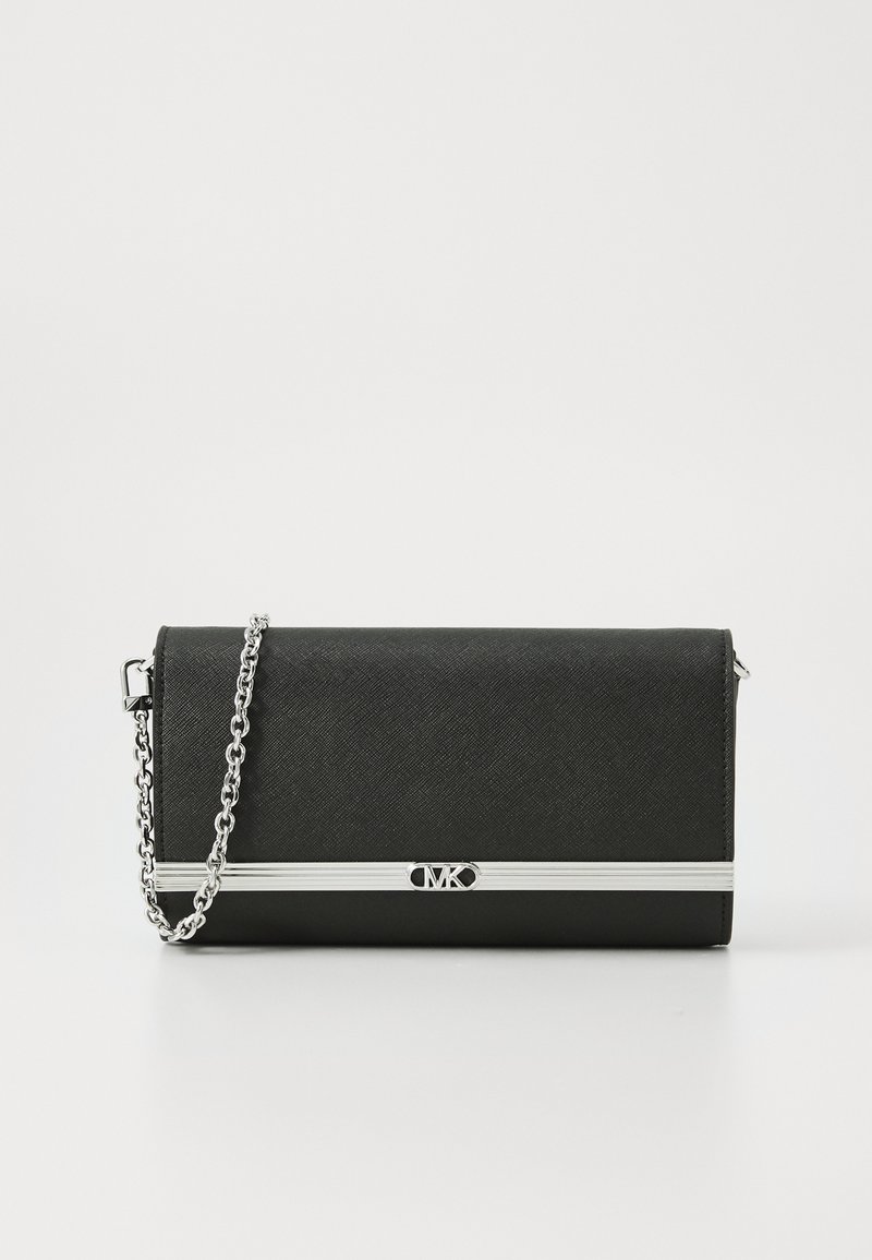Pochette en cuir noir texturé avec bandoulière chaîne argentée et barre horizontale argentée ornée d’un emblème de logo central sur fond blanc.