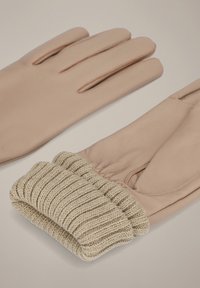Beżowe skórzane rękawiczki z ciasno dzianymi kremowymi mankietami. Rękawiczki mają cztery przedziały na palce oraz subtelne przeszycia wzdłuż krawędzi.