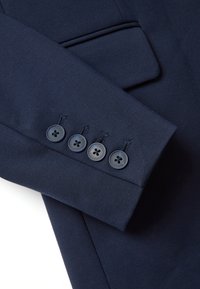 Maniche di giacca blu marina con cinque bottoni scuri, tessuto liscio e design su misura con dettaglio di cucitura decorativa.