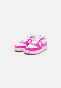 Rosa och vita sneakers med ett smidigt läderöverdrag, vita snören, perforerad tå och gummisula. Har en rosa logotyp på sidan.