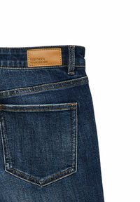 Tumesinised teksapüksid sirge lõikega, millel on üks tagatasku ja beež nahast silt, millel on kiri "VERO MODA WE DO DENIM".