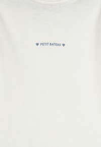 Giacchetto di cotone bianco con collo a girocollo, decorato con testi ricamati in blu "PETIT BATEAU" e cuori disegnati sopra e sotto il testo.