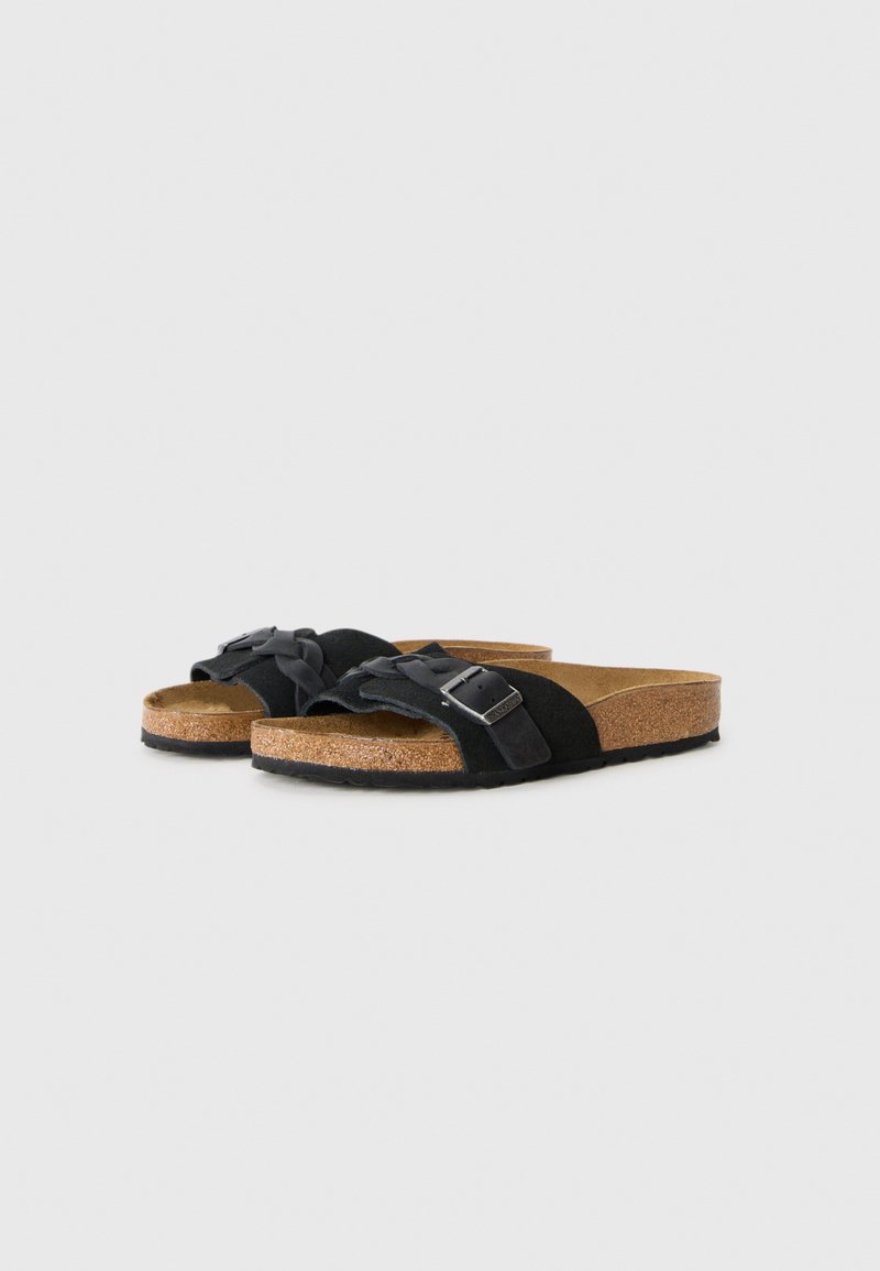 Schwarze Wildledersandalen mit geflochtenen Riemen und silbernen Schnallenakzenten. Korkfußbett und schwarze Außensohle für Komfort und Unterstützung.