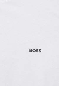 Hvit bomulls-T-skjorte med en svart brodert "BOSS"-logo på venstre bryst. Glatt tekstur og klassisk rund hals-design.