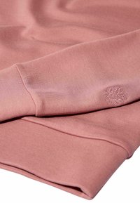 Gefaltetes, staubig rosa Sweatshirt mit gerippten Bündchen und dezentem, auf dem Ärmel gesticktem Logo.