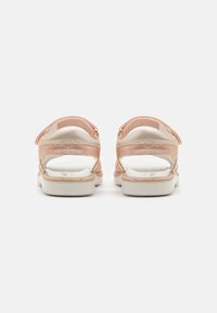 Rosa und beige Sandalen mit verstellbaren Riemen, weichem gepolstertem Fußbett und offenem Design hinten. Strukturiertes Obermaterial und stabiler weißer Sohle.