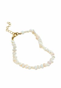 Collier en perles d'eau douce blanches aux formes irrégulières, fermoir en chaîne dorée et chaîne d'extension. Texture lisse avec une légère brillance.