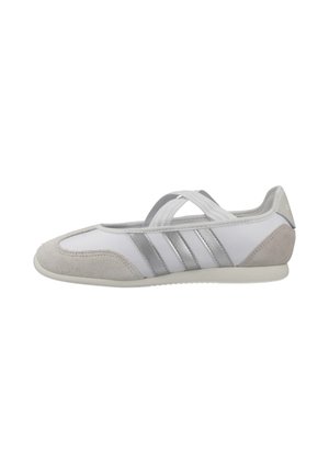 Zapatilla blanca y gris de tipo slip-on con puntera y talón de ante, tres franjas grises en el costado y tiras elásticas cruzadas sobre el empeine.