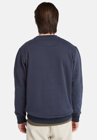 Marineblauwe sweatshirt met een ronde halslijn, ribgebreide manchetten en zoom, en een relaxte pasvorm. Gemaakt van zachte, gestructureerde stof.
