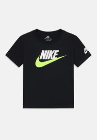 T-shirt di cotone nero a maniche corte, con un audace logo "NIKE" bianco e un motivo con segno di spunta verde neon sul davanti.