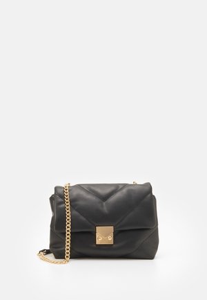 Sac à main en cuir matelassé noir avec fermoir carré doré et bandoulière chaîne assortie sur fond blanc.