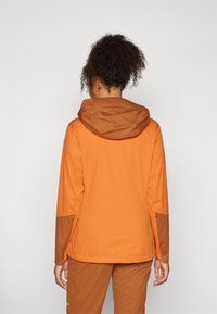 Orange waterproof jacket with a brown hood, featuring a smooth texture, long sleeves, and a fitted silhouette, visible stitching details.