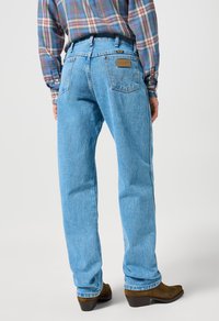Lichtblauwe denim jeans met een rechtvallende pasvorm. Kenmerken zijn onder andere een leren logopatch, twee achterzakken en subtiele vervaging.