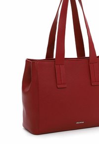 Rode, geweven leren tote bag met twee stevige hengsels, rechthoekige vorm en subtiele branding aan de onderkant.