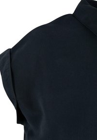 Vêtement bleu foncé en tissu lisse et texturé. Caractéristiques d'un col classique et de manches courtes avec une coupe décontractée. Design minimaliste.