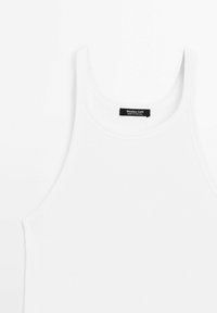 Witte katoenen tanktop met geribbelde textuur, voorzien van een ronde halslijn en brede bandjes. Etiket vermeldt "Massimo Dutti, gemaakt in Portugal."