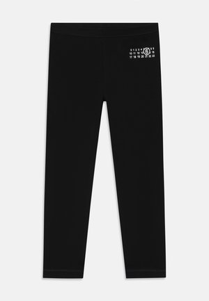 Svart leggings laget av elastisk stoff, med et hvitt numerisk trykk på den øvre siden, med en glatt tekstur og tettsittende design.