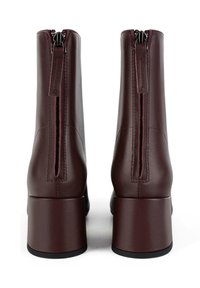 Stivali alla caviglia in pelle bordeaux con tacco a blocco, con una zip verticale sul retro e cuciture a contrasto lungo le cuciture.
