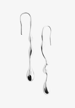 Lange, slanke zilveren druppelvormige oorbellen met een onregelmatig, golvend design en haaksluiting op een witte achtergrond.