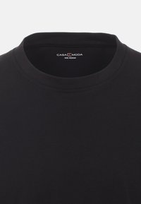 Schwarzes Baumwoll-T-Shirt mit einem Rundhalsausschnitt, versehen mit dem "CASA MODA" Label und einem Größenschild in Medium im Kragen, mit glatter Textur.
