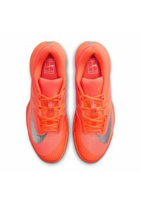 Un paio di scarpe da corsa Nike di un vivace arancione con loghi swoosh argentati, viste dall'alto, che mostrano i lacci e l'interno imbottito.