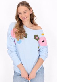 Maglione lavorato a maglia blu chiaro con ricami floreali in rosa, verde e giallo. Presenta un ampio scollo e polsini a coste. Vestibilità casual.