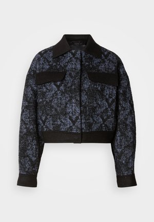 Mustast ja tumesinisest tekstuuriga lühem jakk pikkade varrukate, laiade kraede ja kahe klapiga rinnataskuga valgel taustal.