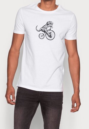 T-shirt bianco in cotone con una grafica nera di un dinosauro che monta una bicicletta sul davanti. Maniche corte e scollatura rotonda.