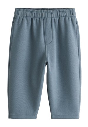 Siniset elastisella vyötäröllä varustetut shortsit, joissa sivutaskut ja näkyvät ompeleet, valmistettu pehmeästä kankaasta.