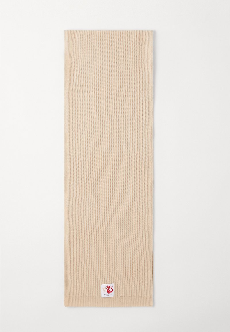 Beige geribde sjaal van zacht materiaal, met een gestructureerd ontwerp en een klein merklabel met een rood logo aan één uiteinde.