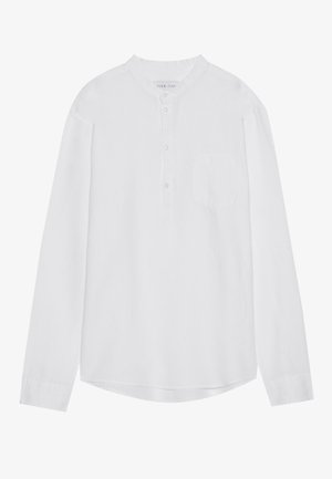 Cămașă albă cu mânecă lungă, guler chinezesc, nasturi pe față, un singur buzunar la piept și o linie de tiv ușor curbată. Fabricată dintr-un material ușor.