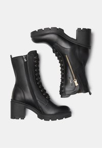 Black leather ankle boots with a chunky heel. Features a side zipper, lace-up front, and metal eyelets for decoration.